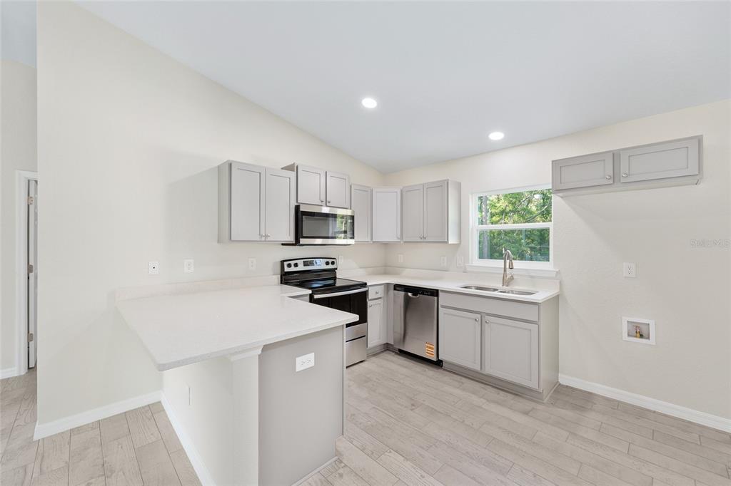 358 Locust Road Ocala, FL 34472 - Photo 19 of 48 a kitchen with a sink a window and stainless steel appliances