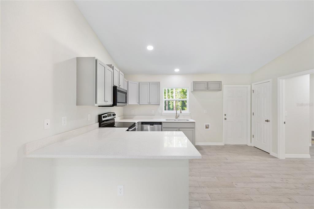 358 Locust Road Ocala, FL 34472 - Photo 20 of 48 a large white kitchen with sink and white cabinets