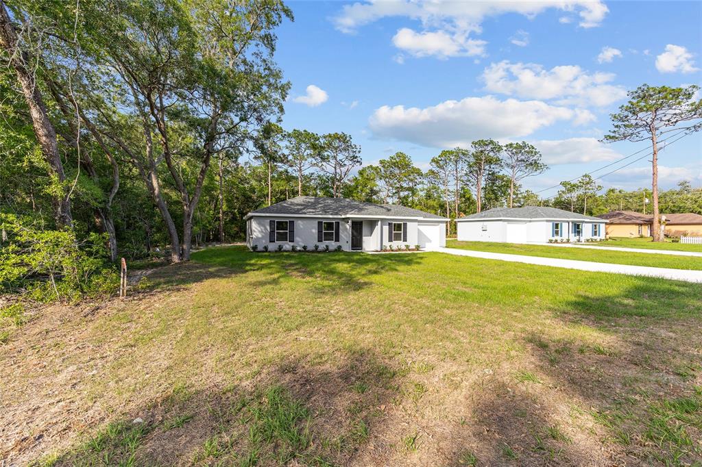 358 Locust Road Ocala, FL 34472 - Photo 2 of 48 a house view with swimming pool and trees in the background