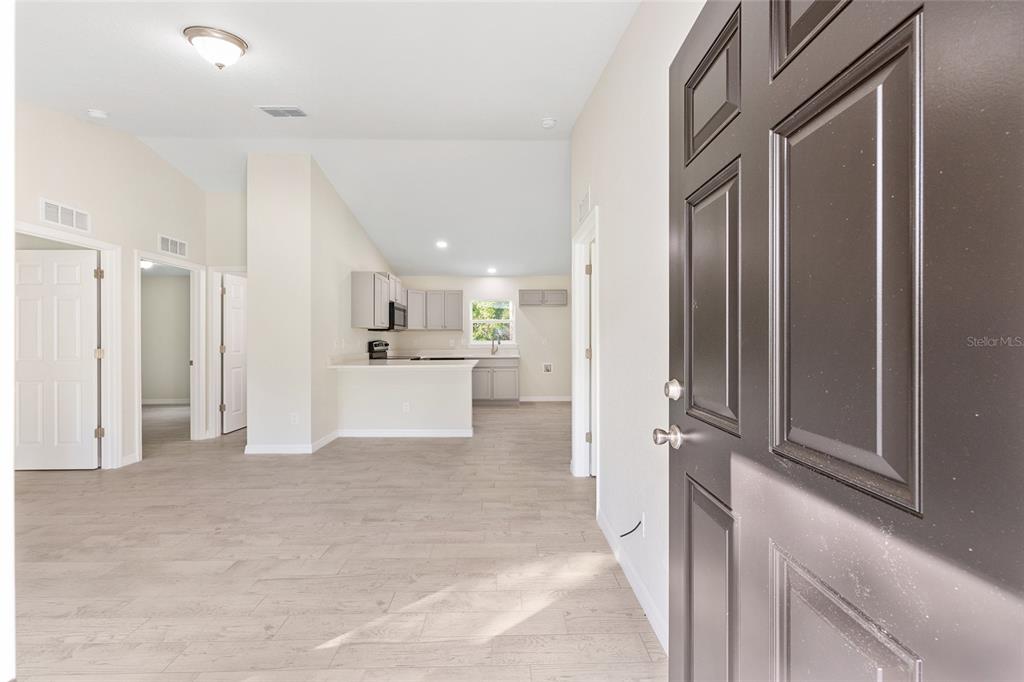 358 Locust Road Ocala, FL 34472 - Photo 10 of 48 a view of a hallway with wooden cabinet and a kitchen