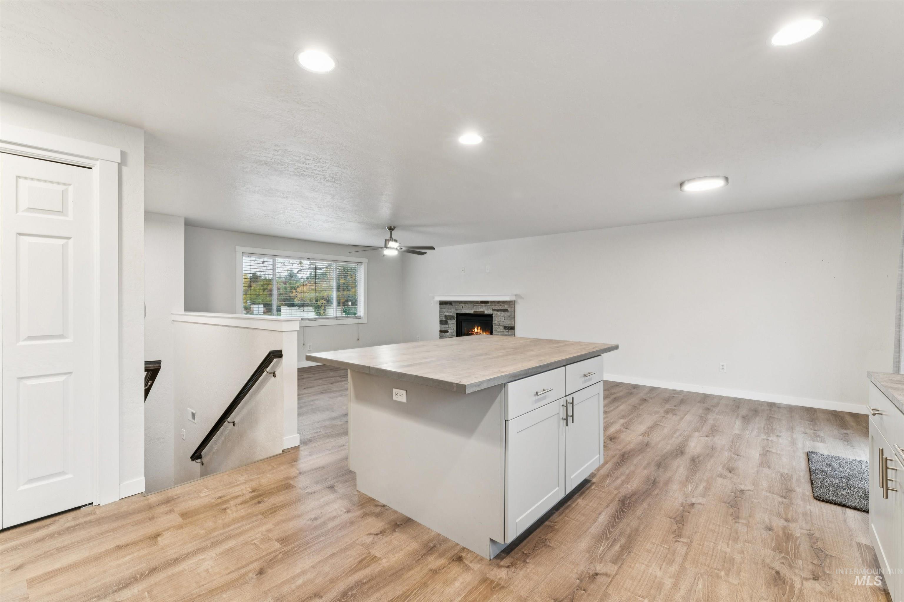 4811 North Leather Way Boise, ID 83713 - Photo 32 of 32 Kitchen with open floor plan, a center island, light wood-type flooring, recessed lighting, and a fireplace