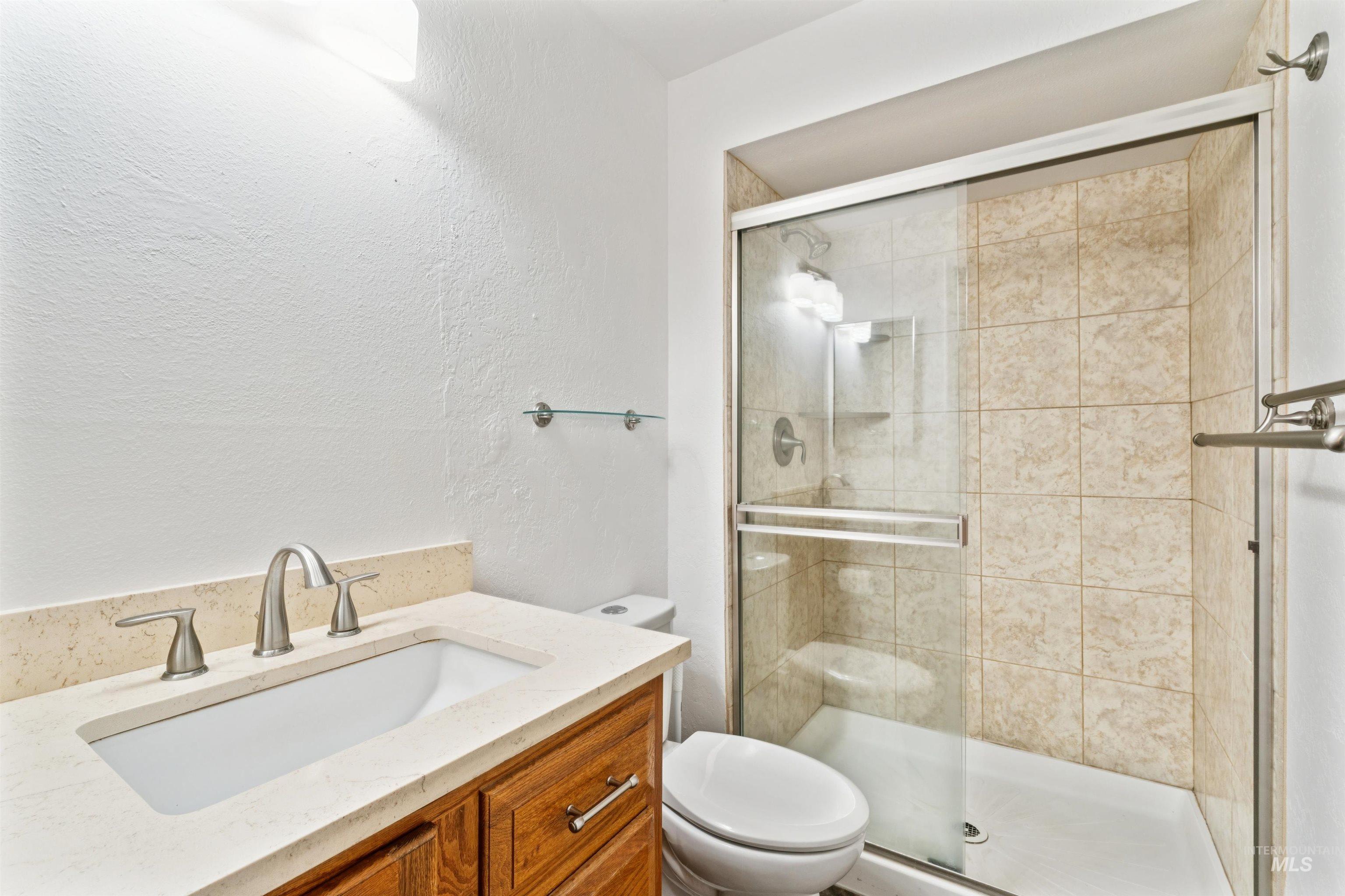 4811 North Leather Way Boise, ID 83713 - Photo 16 of 32 Full bath with vanity, a textured wall, and a stall shower