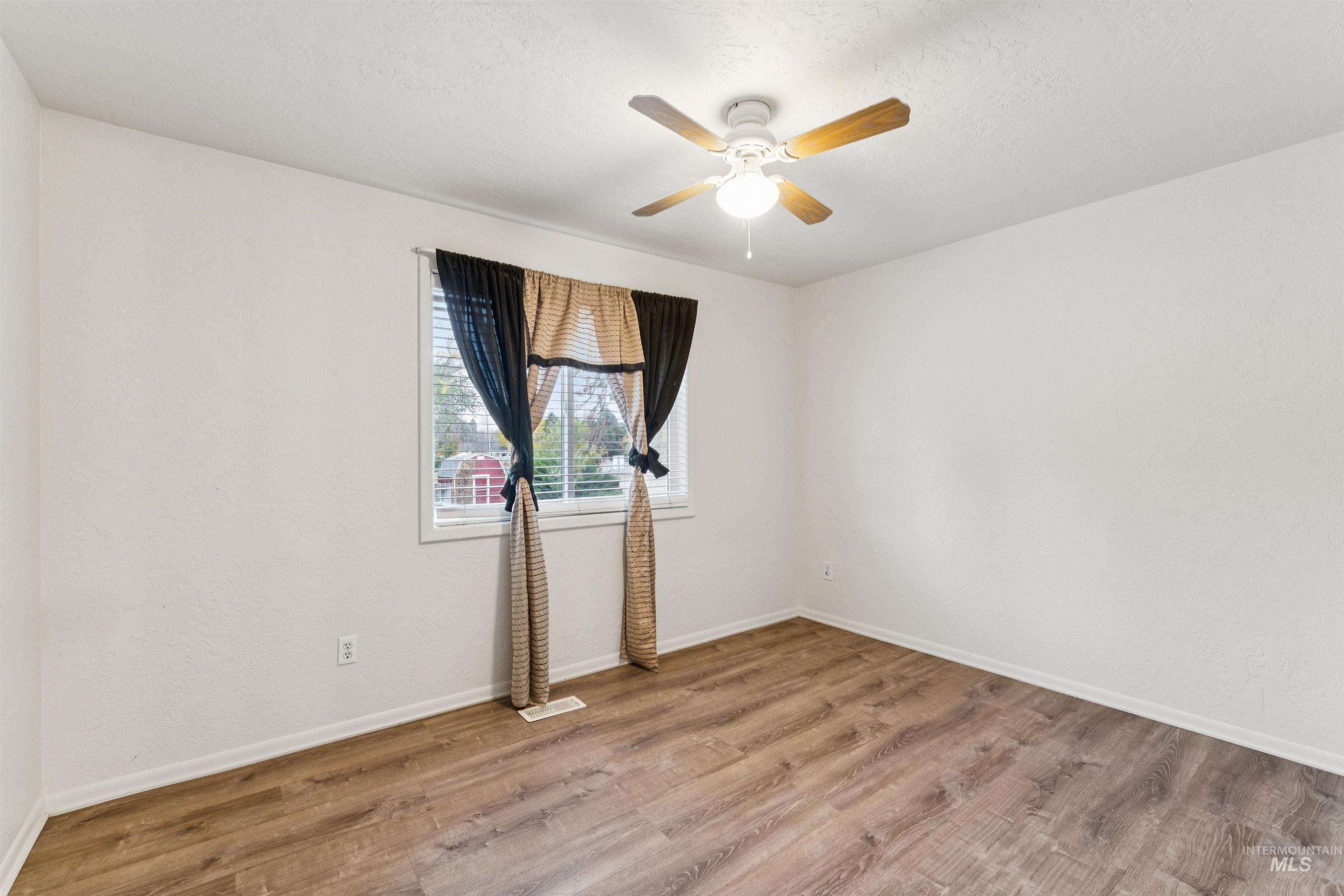4811 North Leather Way Boise, ID 83713 - Photo 17 of 32 Empty room featuring light wood-style flooring, a ceiling fan, and a textured ceiling