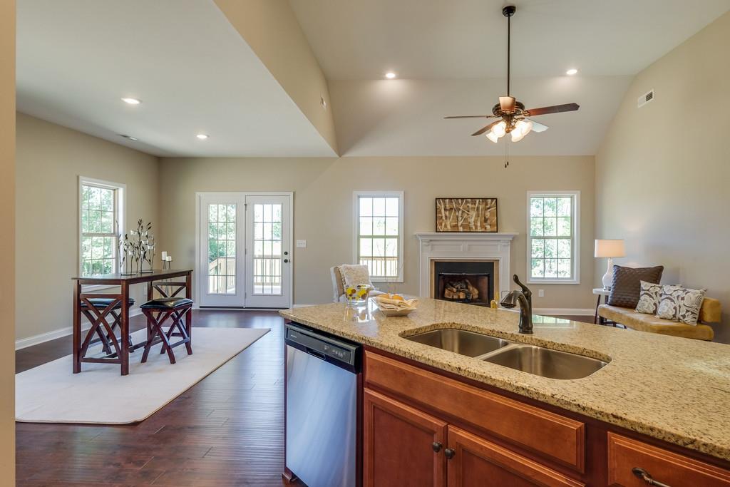 419 Kaiser Road Dickson, TN 37055 - Photo 4 of 27 a kitchen with a refrigerator a sink dishwasher a dining table and chairs with wooden floor