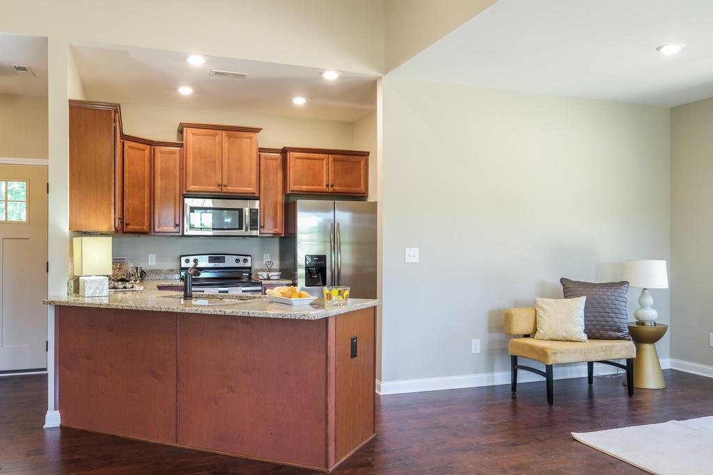 419 Kaiser Road Dickson, TN 37055 - Photo 5 of 27 a kitchen with stainless steel appliances granite countertop a sink a stove a refrigerator a microwave a dining table and chairs