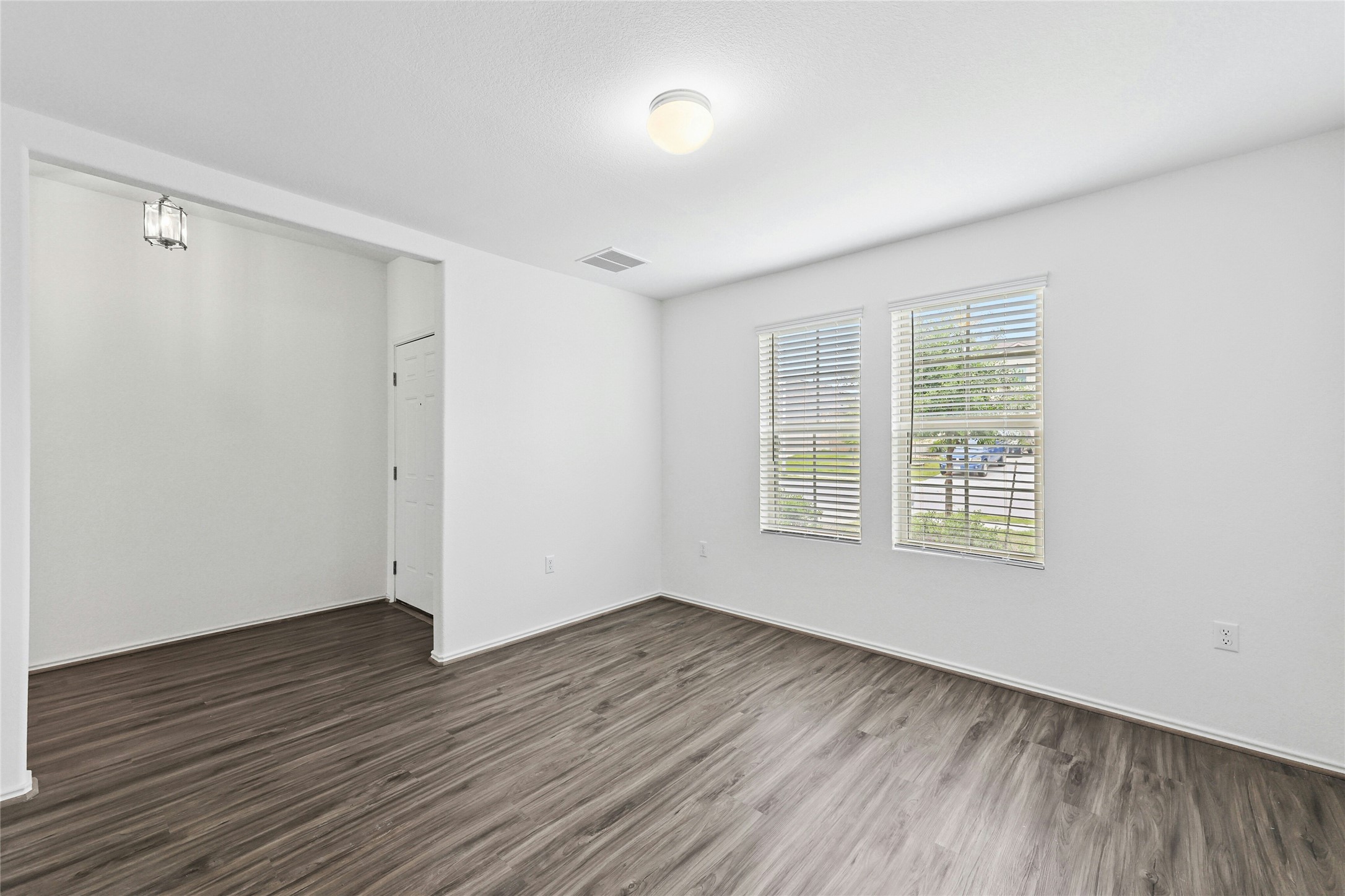 11813 Roscommon Trail Austin, TX 78754 - Photo 20 of 28 a view of an empty room with wooden floor and a window