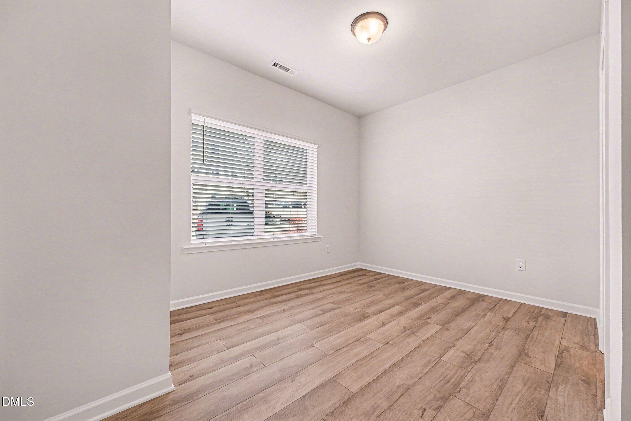 726 Orch Vista Circle Raleigh, NC 27606 - Photo 15 of 28 an empty room with wooden floor and windows