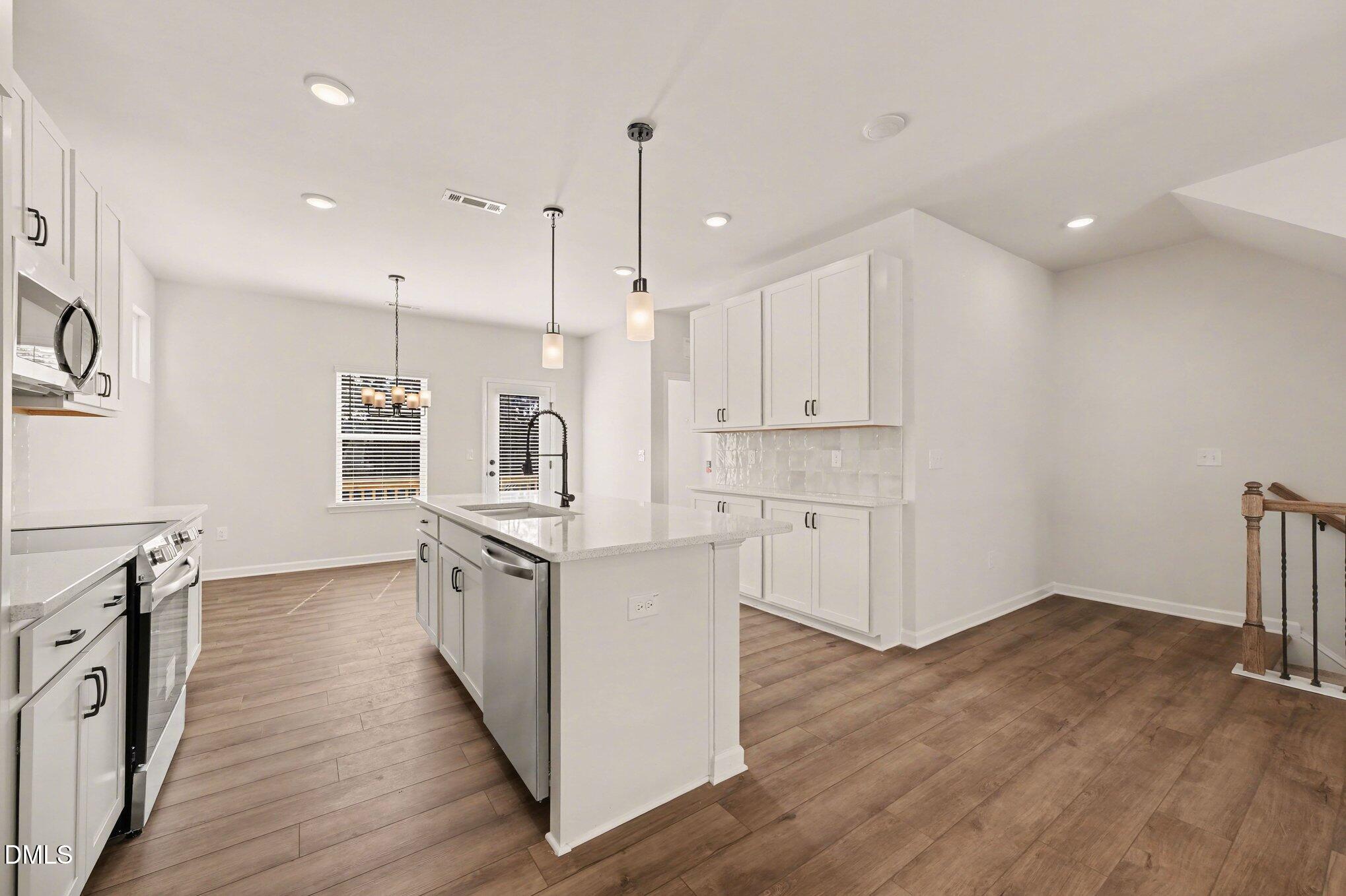 726 Orch Vista Circle Raleigh, NC 27606 - Photo 3 of 28 an open kitchen with wooden floor and stainless steel appliances