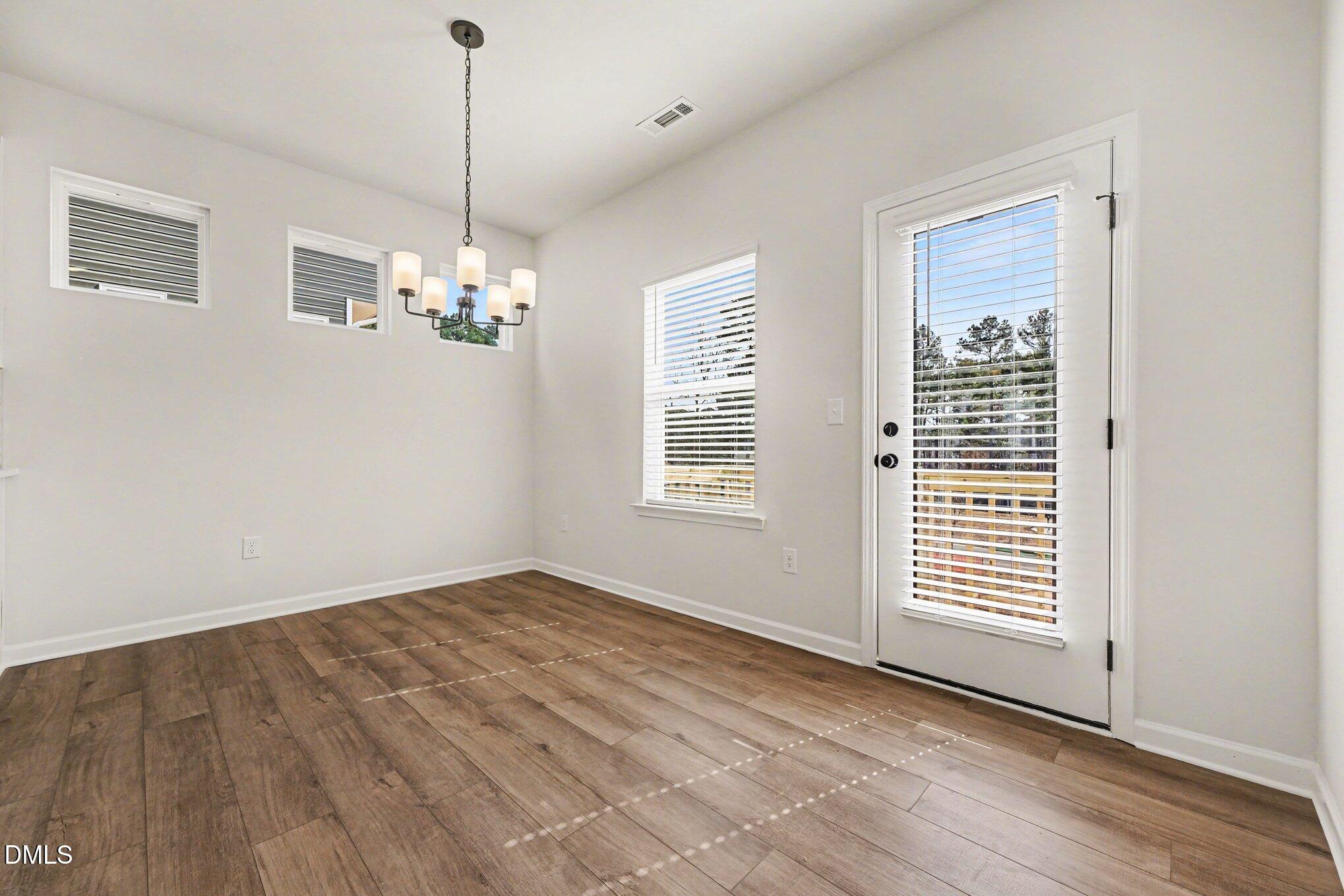 726 Orch Vista Circle Raleigh, NC 27606 - Photo 4 of 28 a view of an empty room with wooden floor and a window
