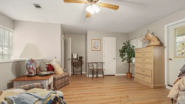 a living room with patio furniture and a potted plants