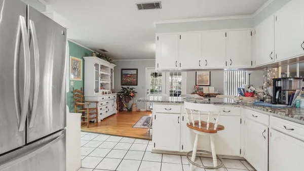 a kitchen with stainless steel appliances kitchen island granite countertop a table and chairs