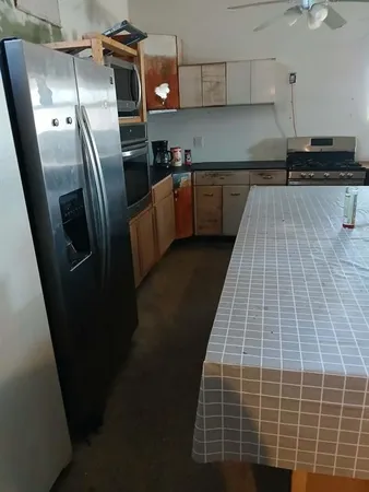 a kitchen with kitchen island a counter space a sink a stove and refrigerator