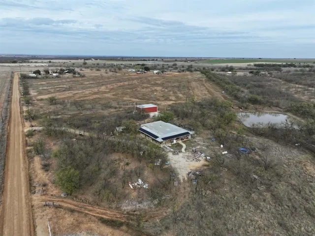 a view of a backyard with lawn chairs and wooden fence