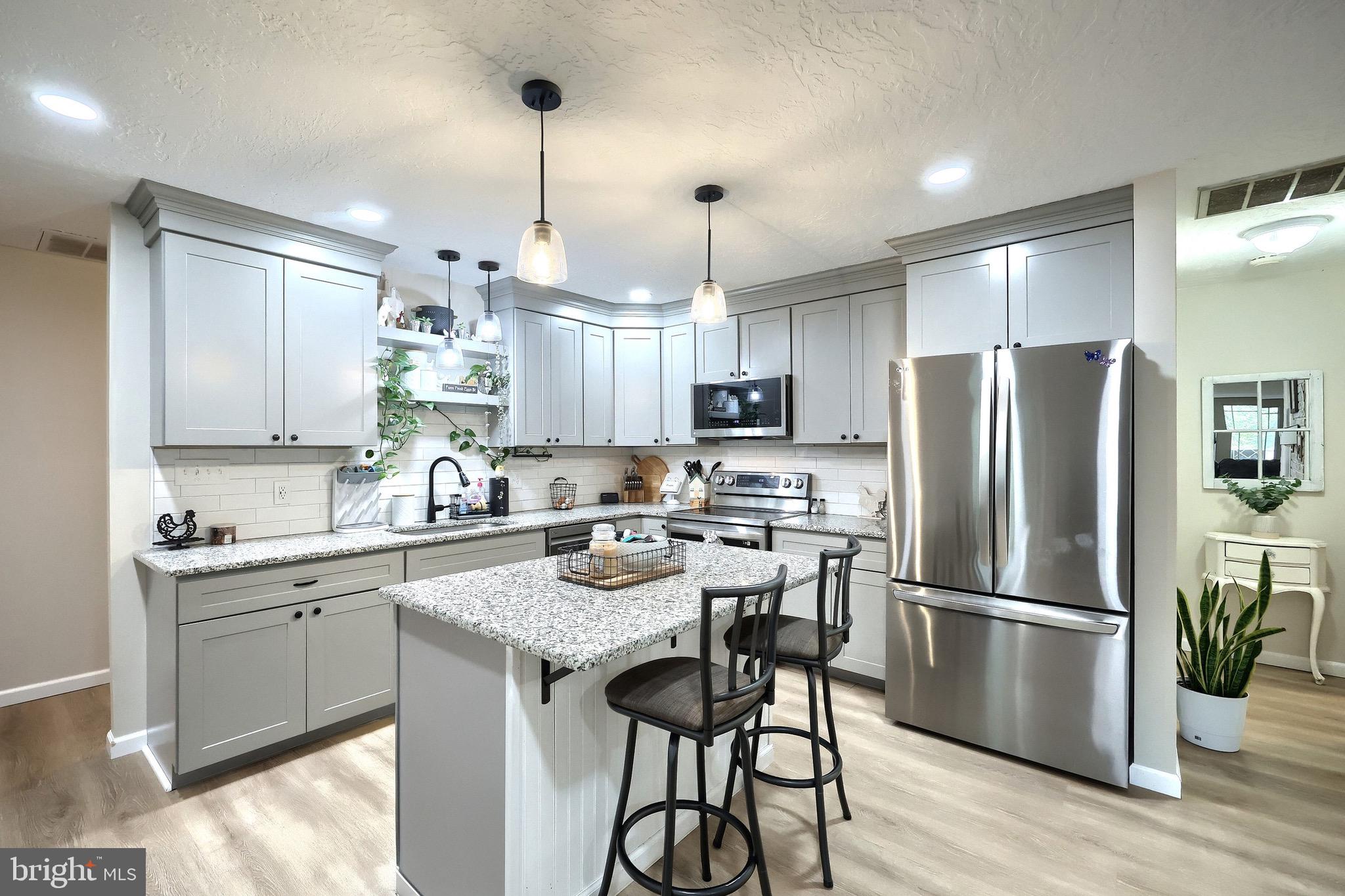 60 Massa Drive Windsor, PA 17366 - Photo 24 of 40 a kitchen with stainless steel appliances granite countertop a refrigerator a sink dishwasher a stove and white countertops with wooden floor
