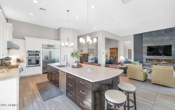 a dining room with stainless steel appliances kitchen island a table and chairs