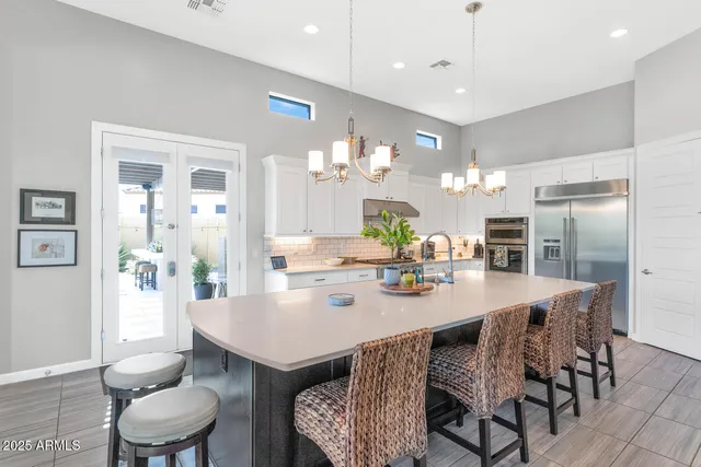 a view of a dining room and livingroom with furniture wooden floor a chandelier