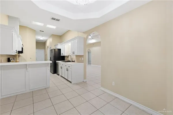 a large white kitchen with cabinets and a sink