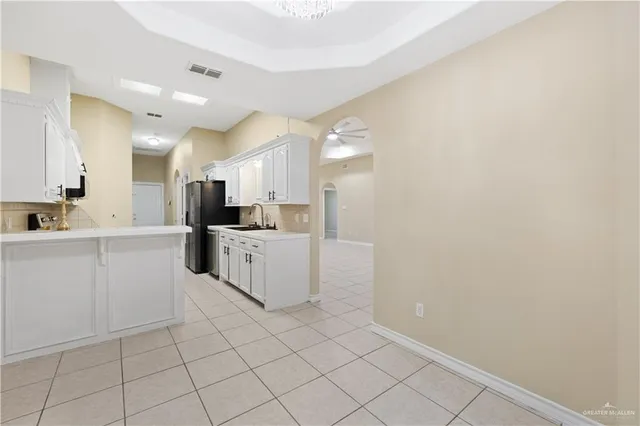 a large white kitchen with cabinets and a sink