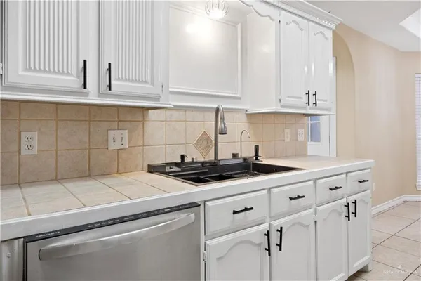 a kitchen with granite countertop white cabinets and white appliances