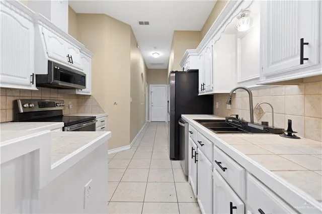 a kitchen with a sink a stove and refrigerator
