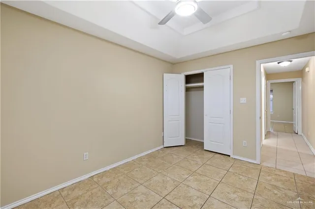 an empty room with a ceiling fan and glass door