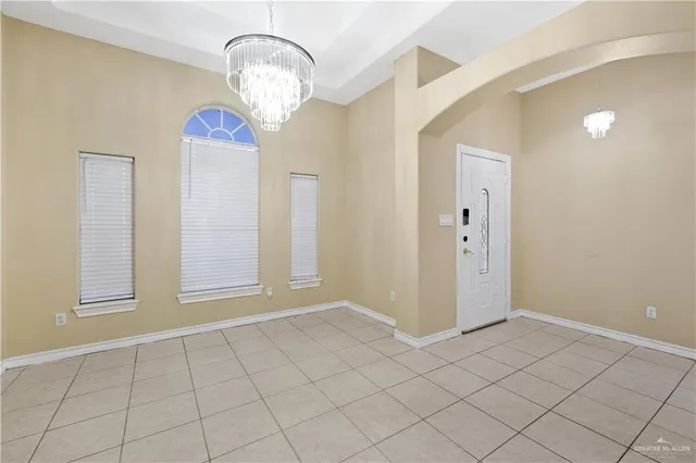 an empty room with chandelier fan