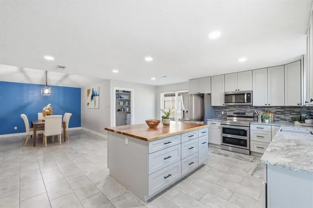 a kitchen with stainless steel appliances a stove refrigerator sink and microwave