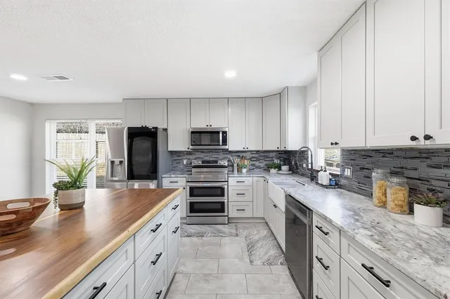 a kitchen with granite countertop a sink stove and refrigerator