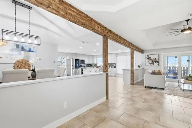 a living room with stainless steel appliances kitchen island granite countertop a sink and cabinets