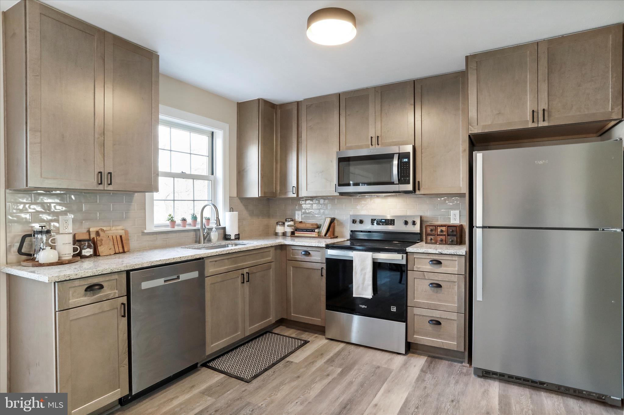 1517 Kendrick Ford Road Front Royal, VA 22630 - Photo 3 of 39 a kitchen with stainless steel appliances granite countertop a stove a sink dishwasher a refrigerator and a microwave oven with wooden floor