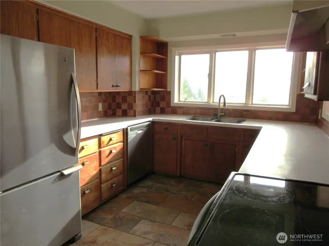 a kitchen with stainless steel appliances granite countertop a refrigerator a stove a sink and a refrigerator