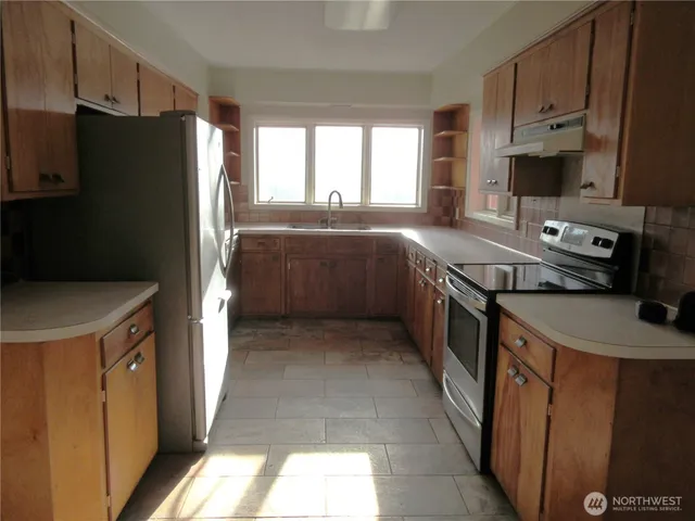 a kitchen with a stove a refrigerator and a dining table
