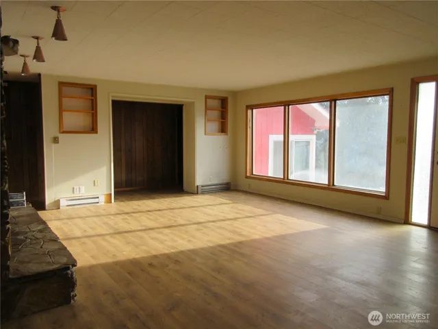 a view of empty room with wooden floor and fireplace