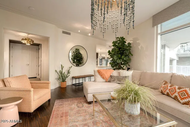 a living room with furniture a clock and a potted plant