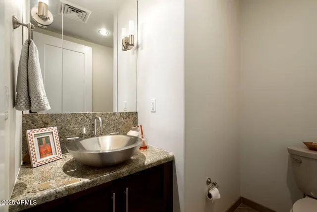 a bathroom with a granite countertop sink and a mirror