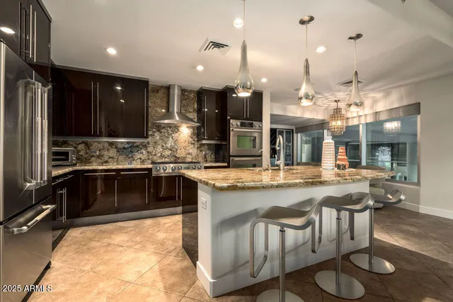 a kitchen with stainless steel appliances granite countertop a stove and white cabinets