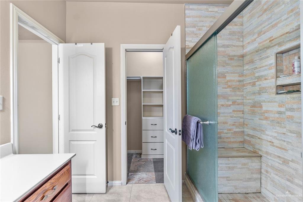 2904 Victoria Street Hidalgo, TX 78557 - Photo 12 of 25 Full bathroom with a stall shower, vanity, a spacious closet, and light tile patterned floors