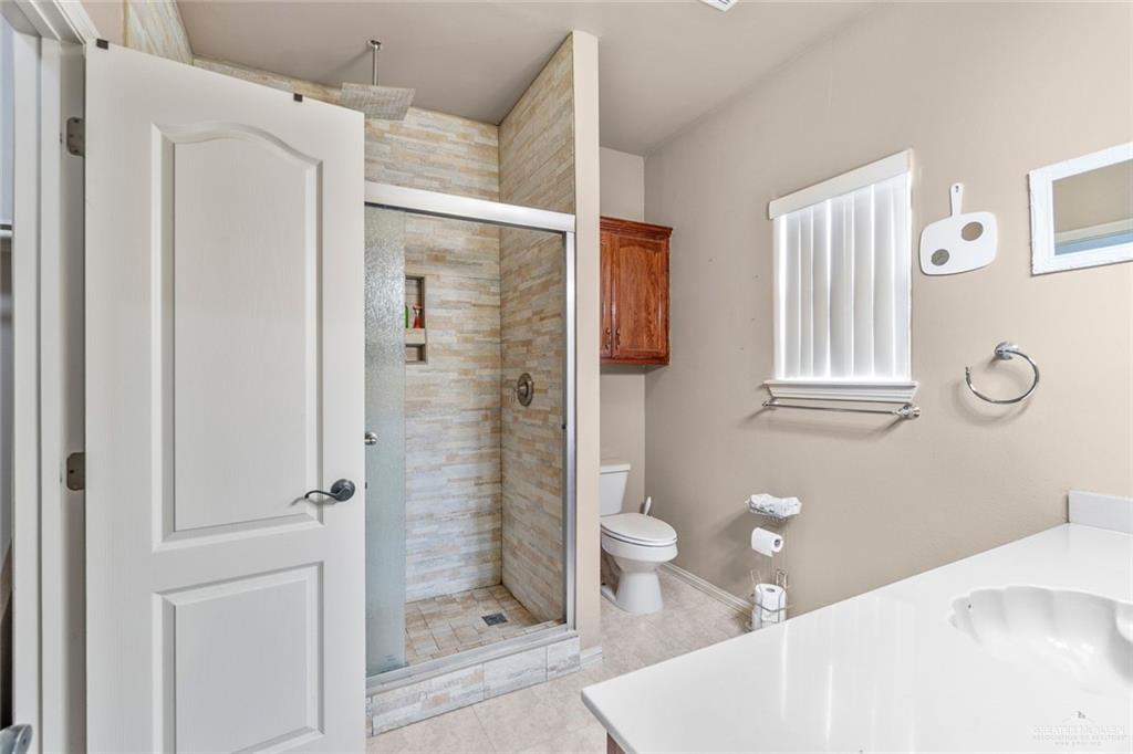 2904 Victoria Street Hidalgo, TX 78557 - Photo 13 of 25 Full bath featuring a shower stall, vanity, and light tile patterned flooring
