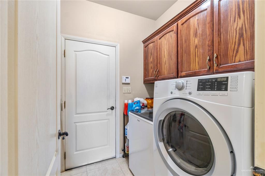 2904 Victoria Street Hidalgo, TX 78557 - Photo 19 of 25 Laundry room featuring light tile patterned floors, cabinet space, and washing machine and clothes dryer