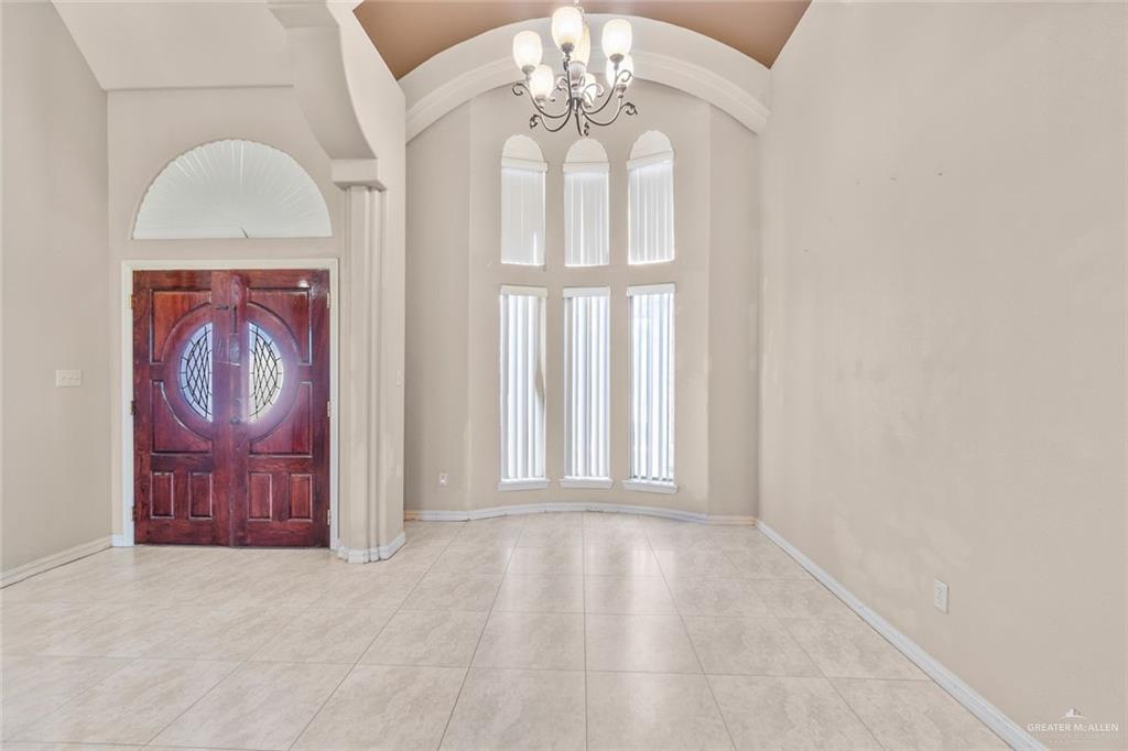 2904 Victoria Street Hidalgo, TX 78557 - Photo 5 of 25 Foyer entrance featuring a chandelier, tile patterned floors, and high vaulted ceiling