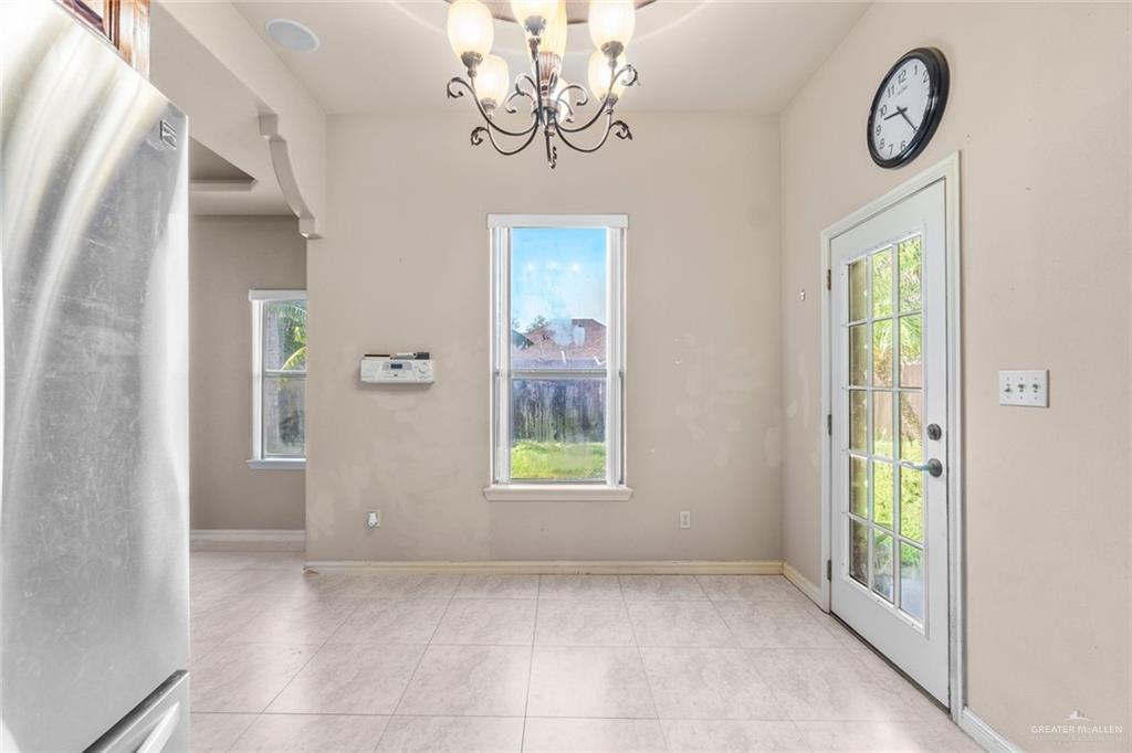 2904 Victoria Street Hidalgo, TX 78557 - Photo 9 of 25 Unfurnished dining area with a chandelier and light tile patterned floors