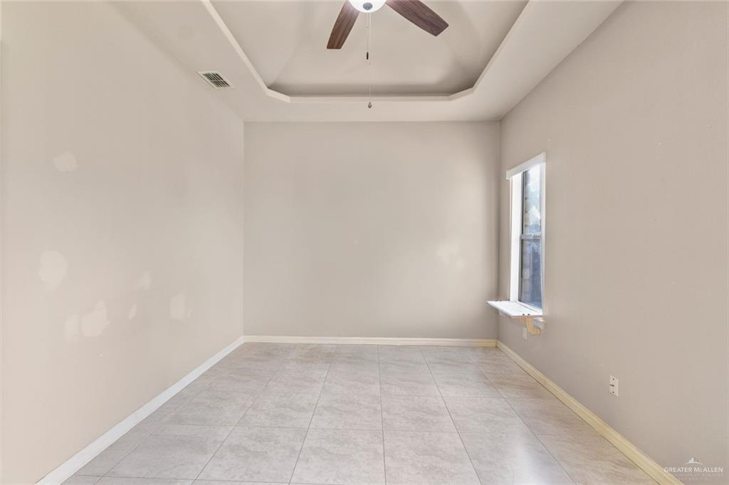 2904 Victoria Street Hidalgo, TX 78557 - Photo 10 of 25 Unfurnished room with a raised ceiling, ceiling fan, and light tile patterned flooring