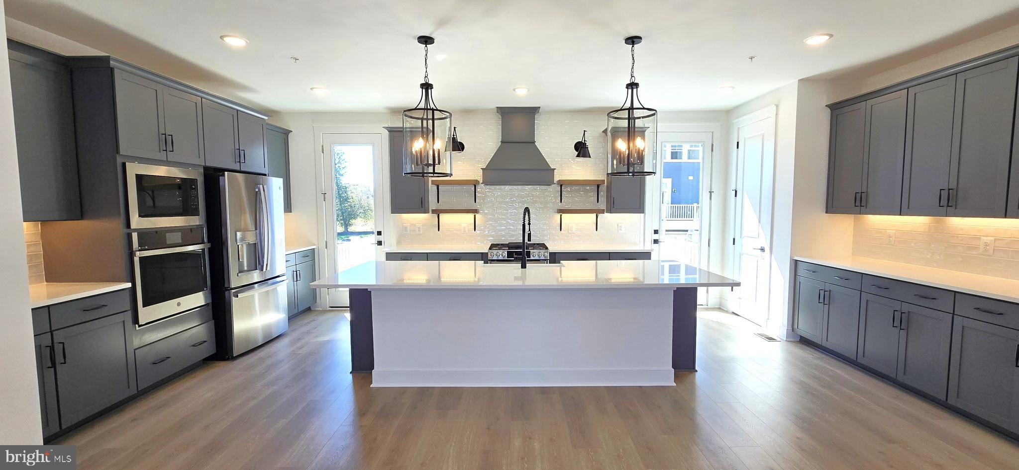 1726 Blacksmith Way Frederick, MD 21702 - Photo 11 of 64 a kitchen with stainless steel appliances kitchen island granite countertop a refrigerator and a stove top oven
