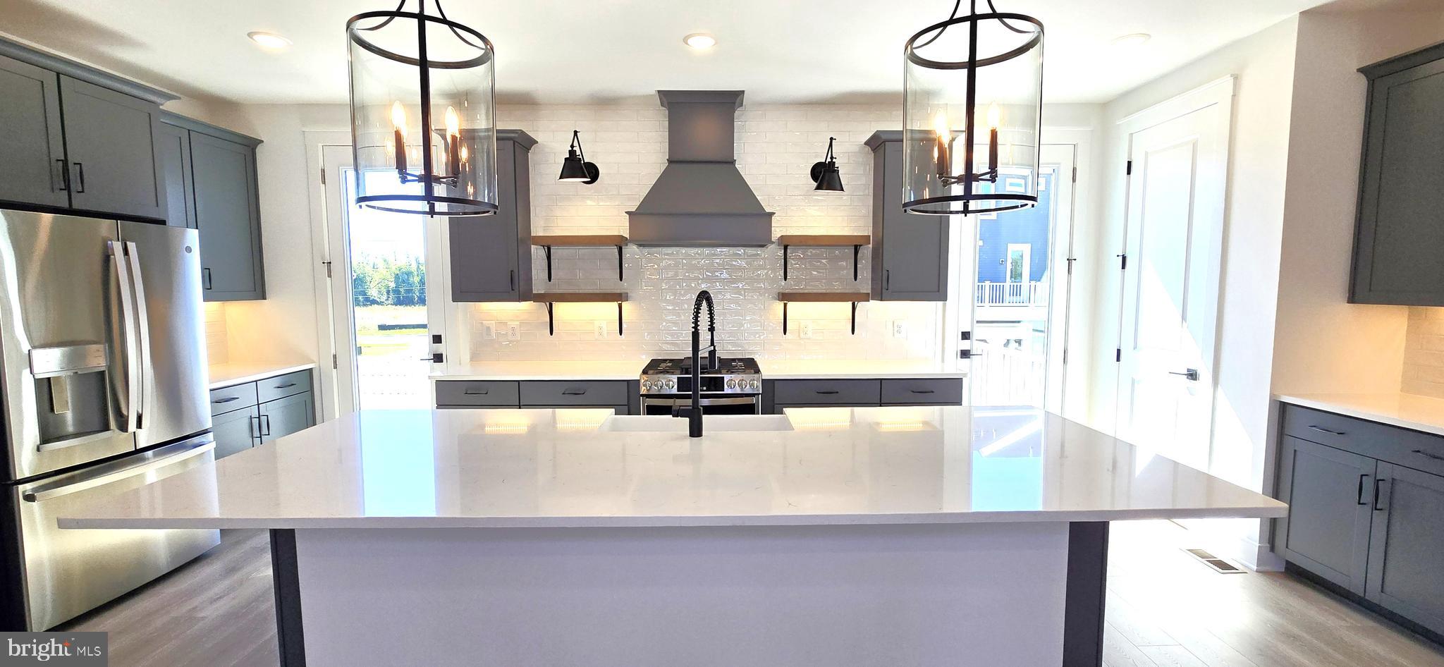 1726 Blacksmith Way Frederick, MD 21702 - Photo 14 of 64 a kitchen with stainless steel appliances kitchen island granite countertop a refrigerator a stove and white cabinets with wooden floor