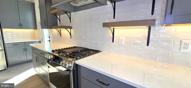 a kitchen with a refrigerator and a stove top oven