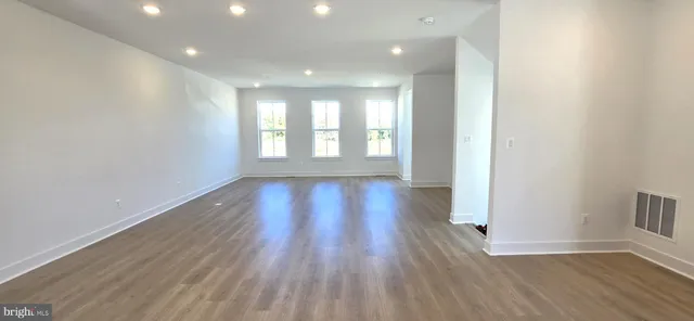 a large kitchen with stainless steel appliances kitchen island a large counter tops and a living room view