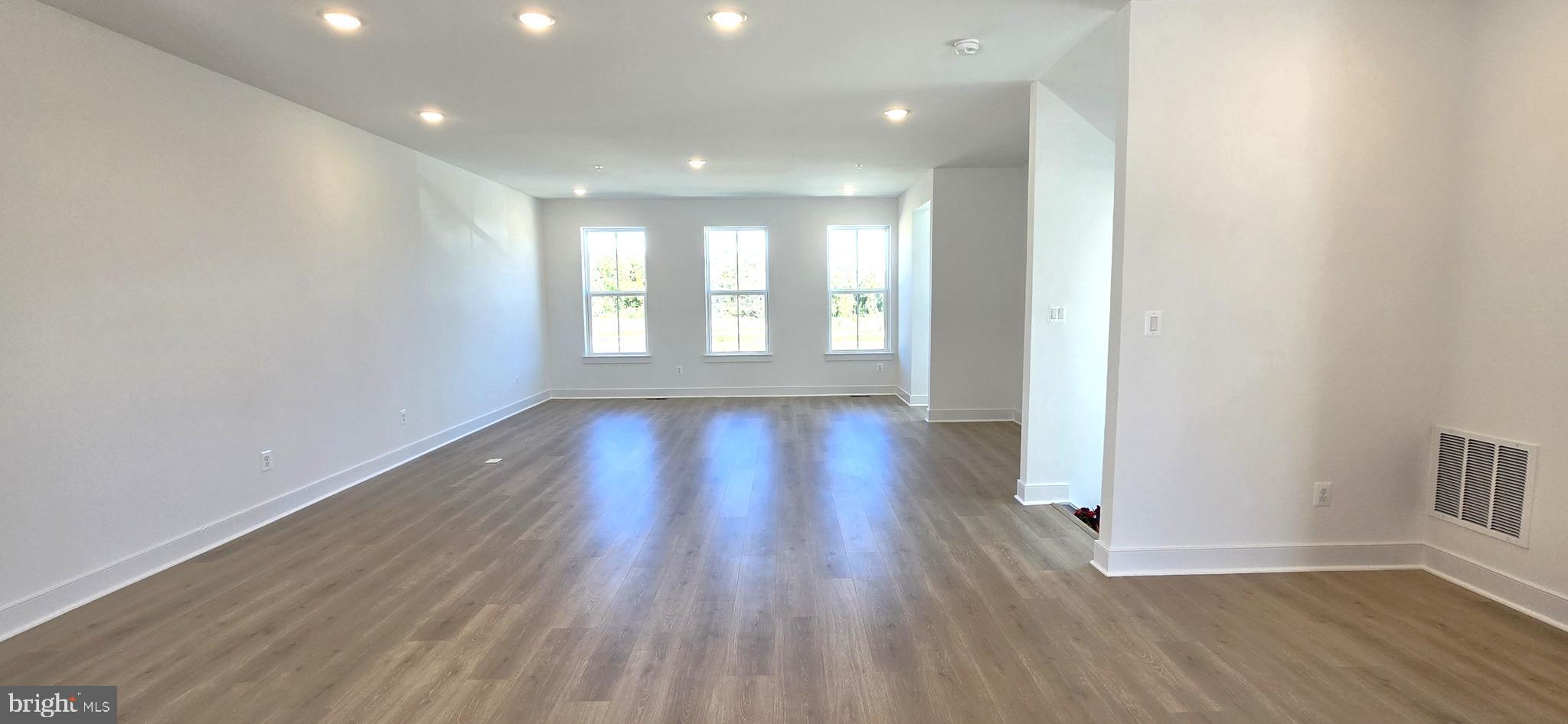 1726 Blacksmith Way Frederick, MD 21702 - Photo 18 of 64 a view of an empty room with a window and wooden floor