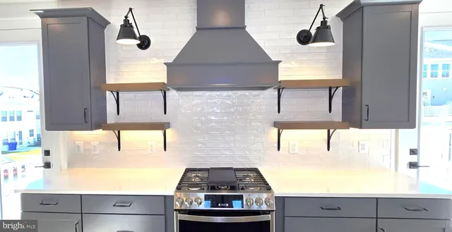 a kitchen with stainless steel appliances granite countertop a sink a stove and a refrigerator