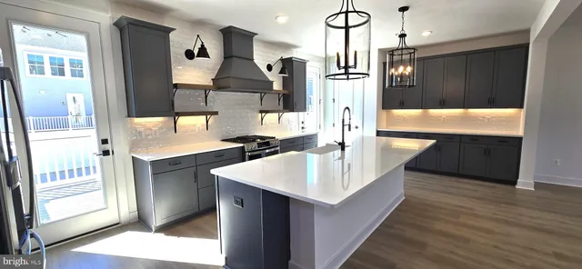 a view of a kitchen with wooden floor and electronic appliances
