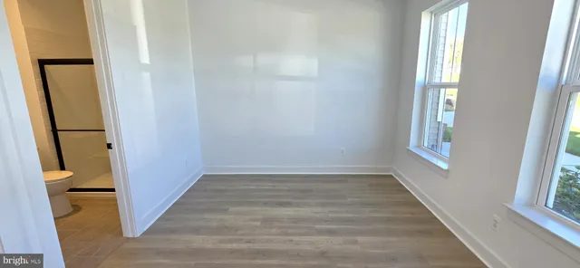 a view of a hallway with wooden floor and closet area